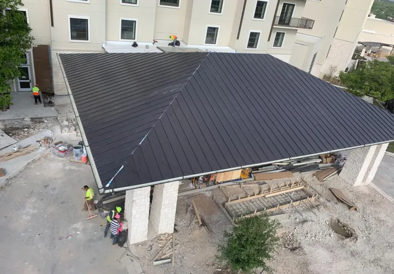 Metal roofing installation team working on a commercial building in Lancaster